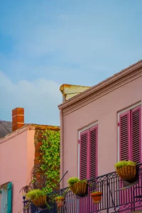 Pink building with plants out on balcony