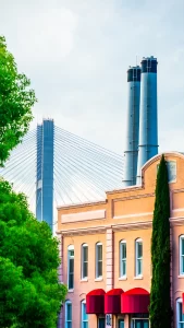Bridge behind older cream colored building with red canopys