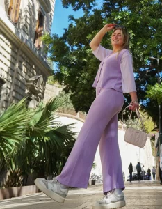 Sydney Meyer in monochrome purple with building and greenery in the background